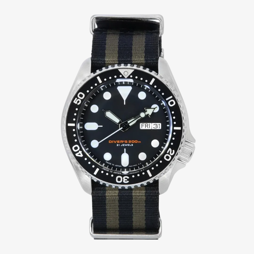 A silver-tone diver watch with a black dial, black rotating bezel, and a striped fabric strap in navy and olive green, shown against a plain white background.